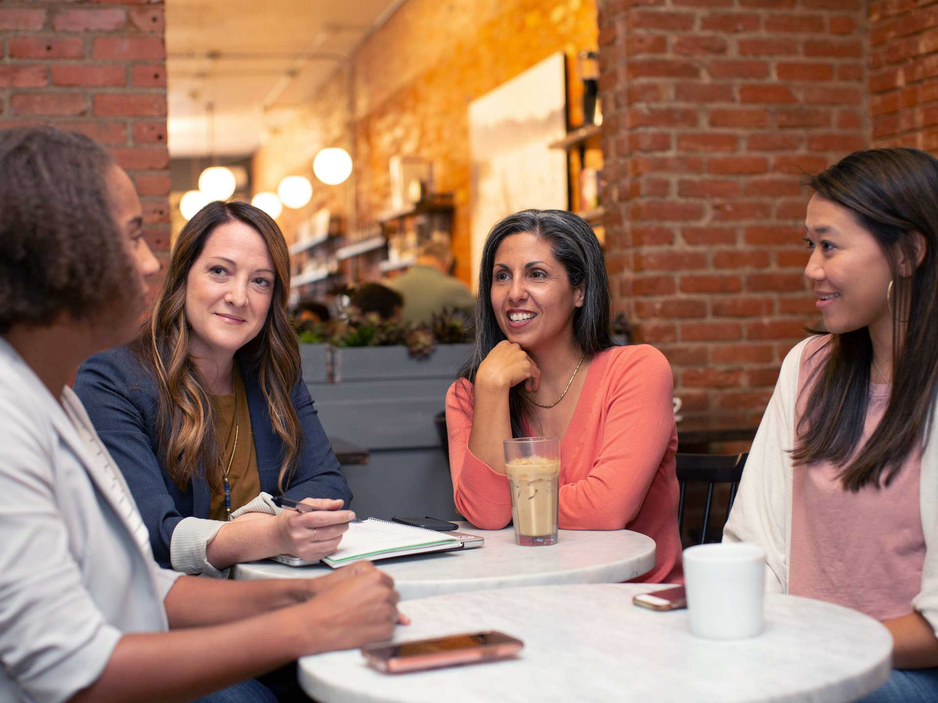 A group of women sitting at a table having a conversation