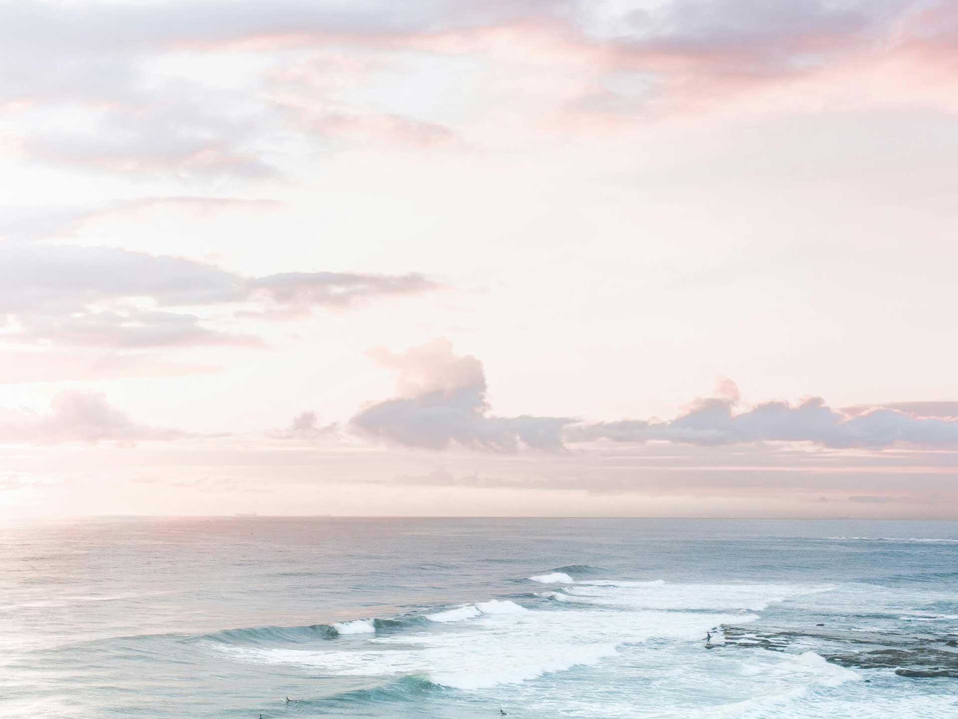 dawn breaking over the sea in soft pastel colours